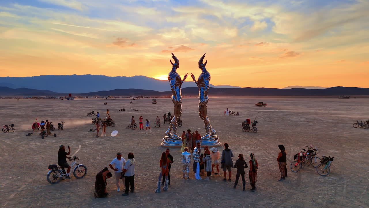 Nevada, USA, 22 August 2025: Tall metallic statues at Burning Man sunset. Two tall metallic humanoid statues face each other at Burning Man desert festival at sunset
