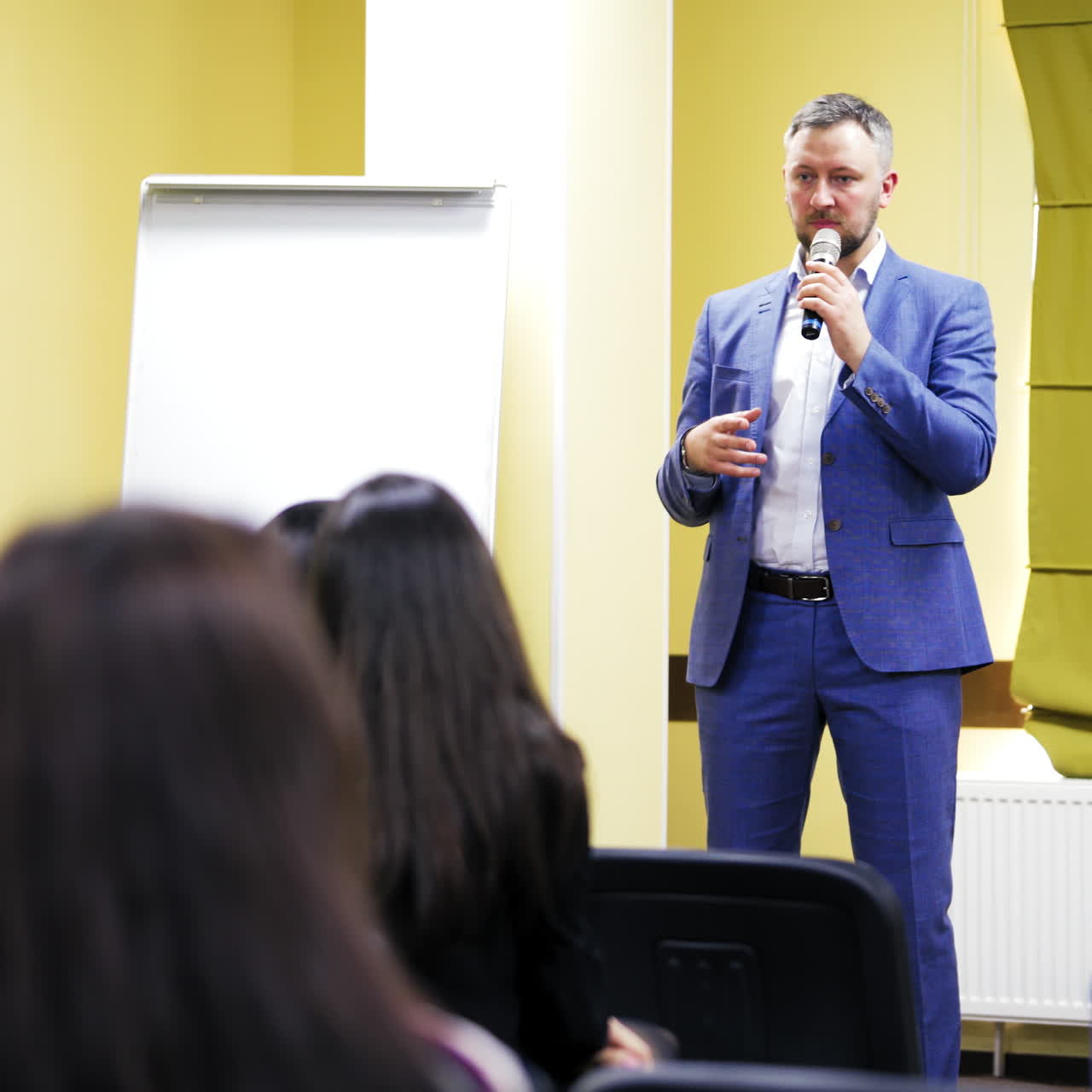 Speaker on the podium. People at the conference hall. Rear view
