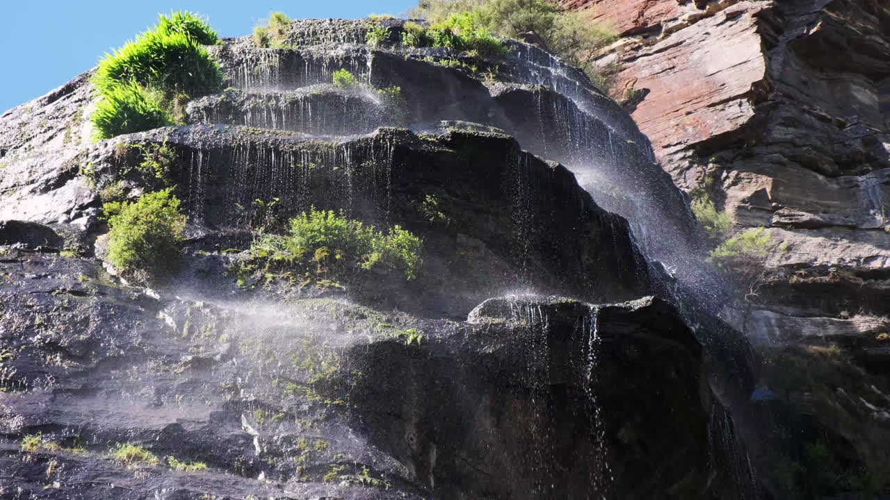 panorámica a través de una cascada brumosa contra un cielo azul