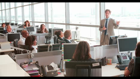business colleagues stand talking in a busy office, close up