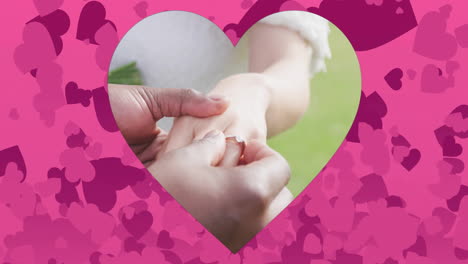 colocación de anillo en el dedo, manos dentro de forma de corazón sobre animación de corazones rosados