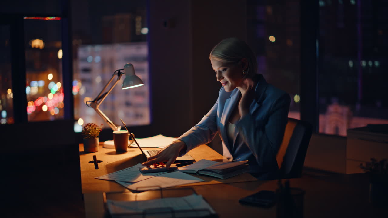 Smiling businesswoman searching internet in evening office. Manager working