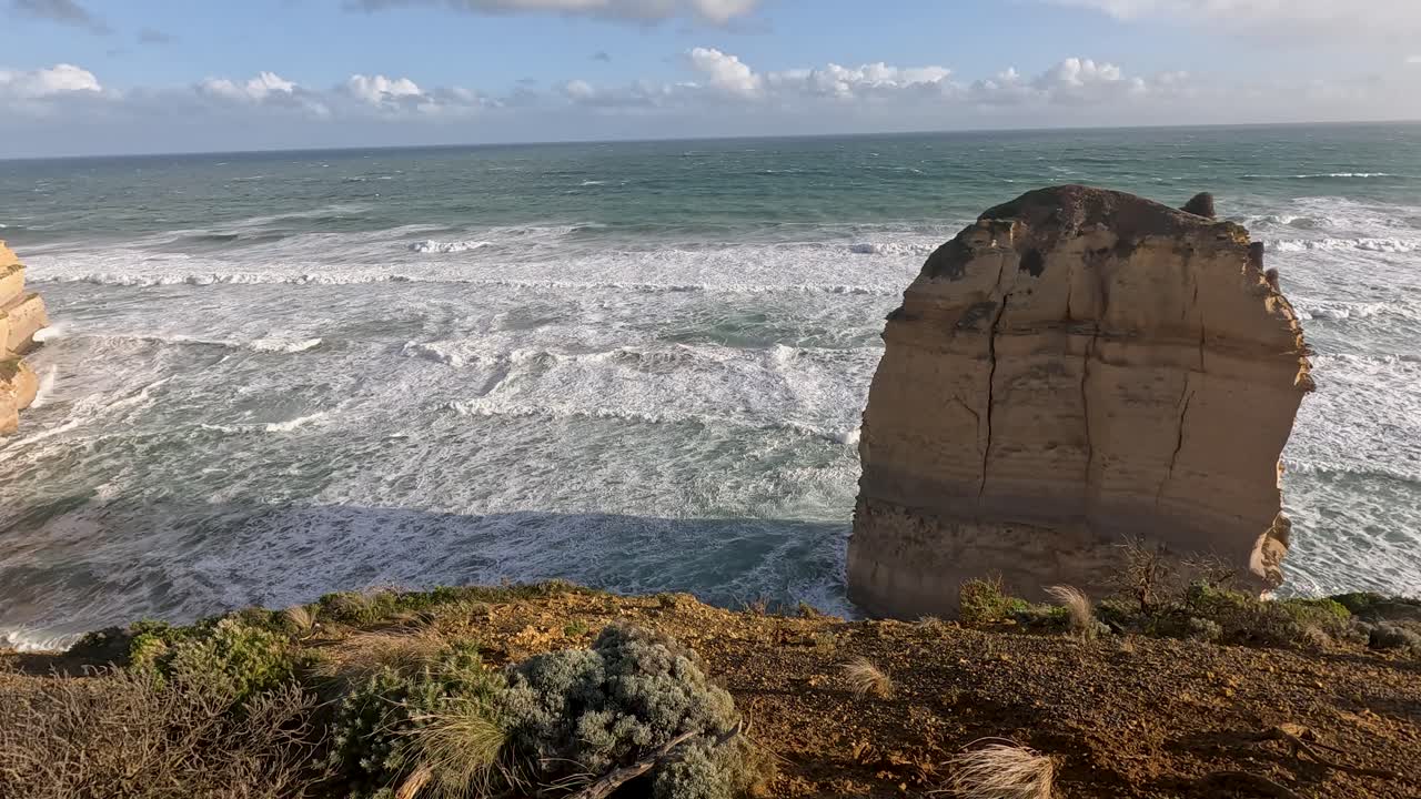 Ocean waves crash against iconic limestone formations