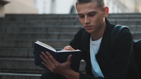 young student writing notes outdoors.