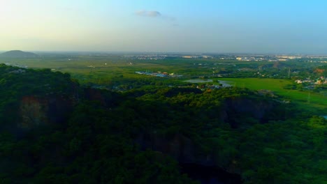 Complete-360-degree-panning-drone-shot-showing-a-city-with-roads,-houses-and-lakes