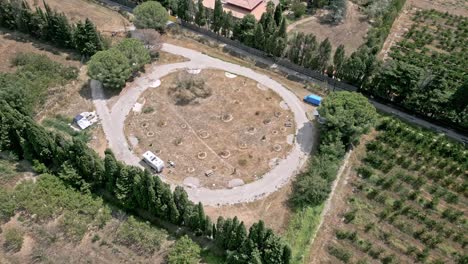 aerial view of a camping car area in ortaffa, france. the camera is slowly moving forward, showing the circular layout of the area and the surrounding landscape