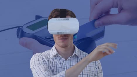 Animation-of-businessman-wearing-vr-headset-touching-virtual-screen-over-payment-terminal