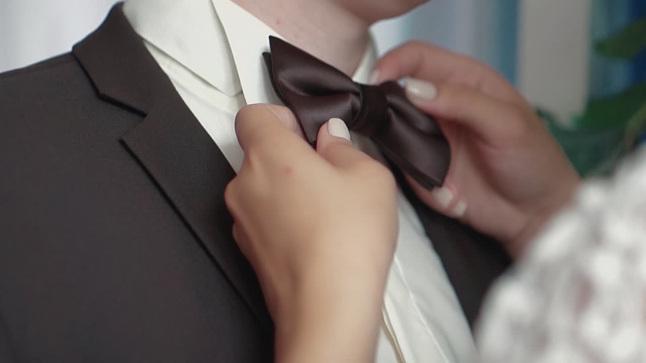 소녀는 남자친구와  ⁇ 타이를 조정합니다.