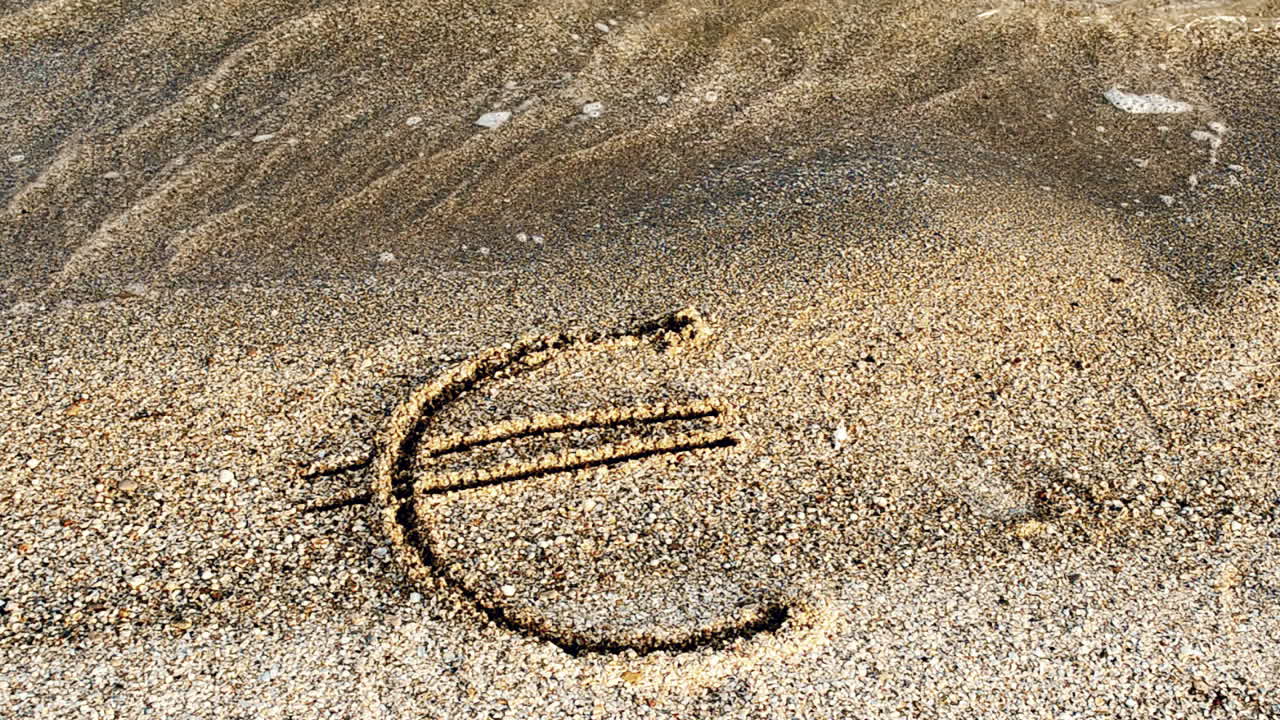 Eurotegn i sandet. Sand og valuta.