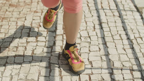 close-up of womans feet running on pavement