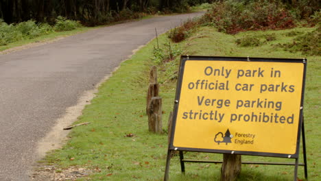 un cartel de forestry england sobre el estacionamiento solo en aparcamientos oficiales