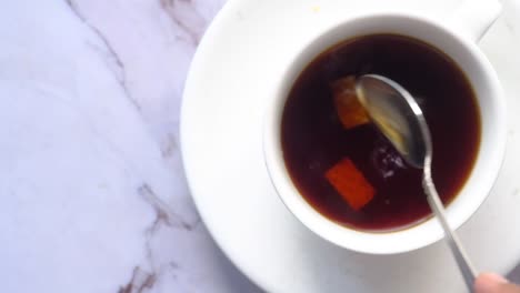 close-up of a cup of coffee or tea with sugar cubes and a spoon