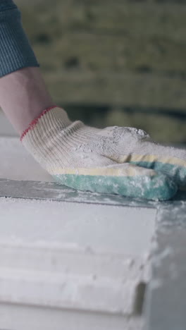skilled man hands in white gloves and blue sweatshirt measure gypsum plasterboard and ruler with pencil close view