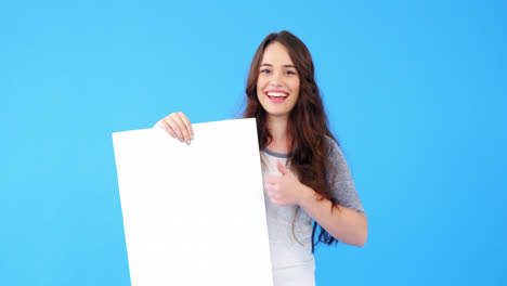 hermosa mujer sosteniendo un cartel en blanco y mostrando los pulgares hacia arriba