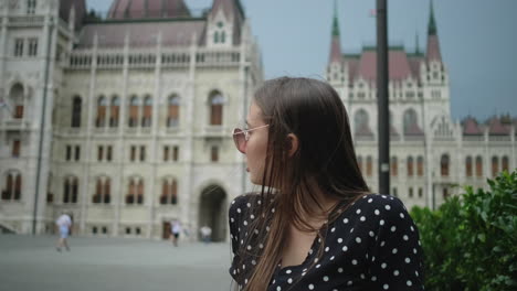 woman in budapest in front of the parliament building