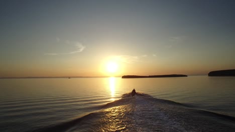 toma aérea de un jet ski que va hacia el sol, mar de cortez, baja california sur