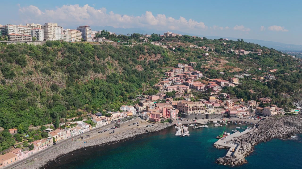 Ampia veduta aerea panoramica di Santa Maria la Scala, un villaggio di pescatori circondato da scogliere di lava basaltica nera vicino all'Etna ad Acireale, Catania, Sicilia, Italia, una destinazione popolare sulla costa ionica