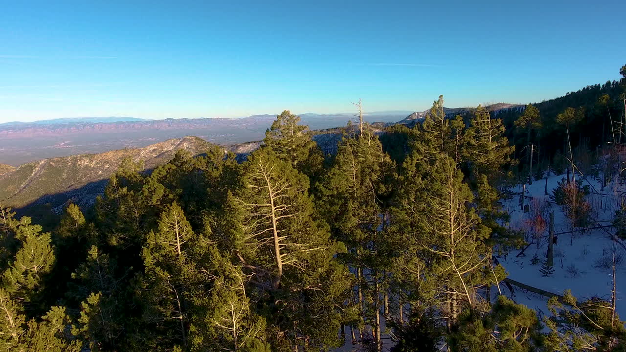 Cinematic rotating and rising drone shot of snow covered Mount Lemmon Arizona