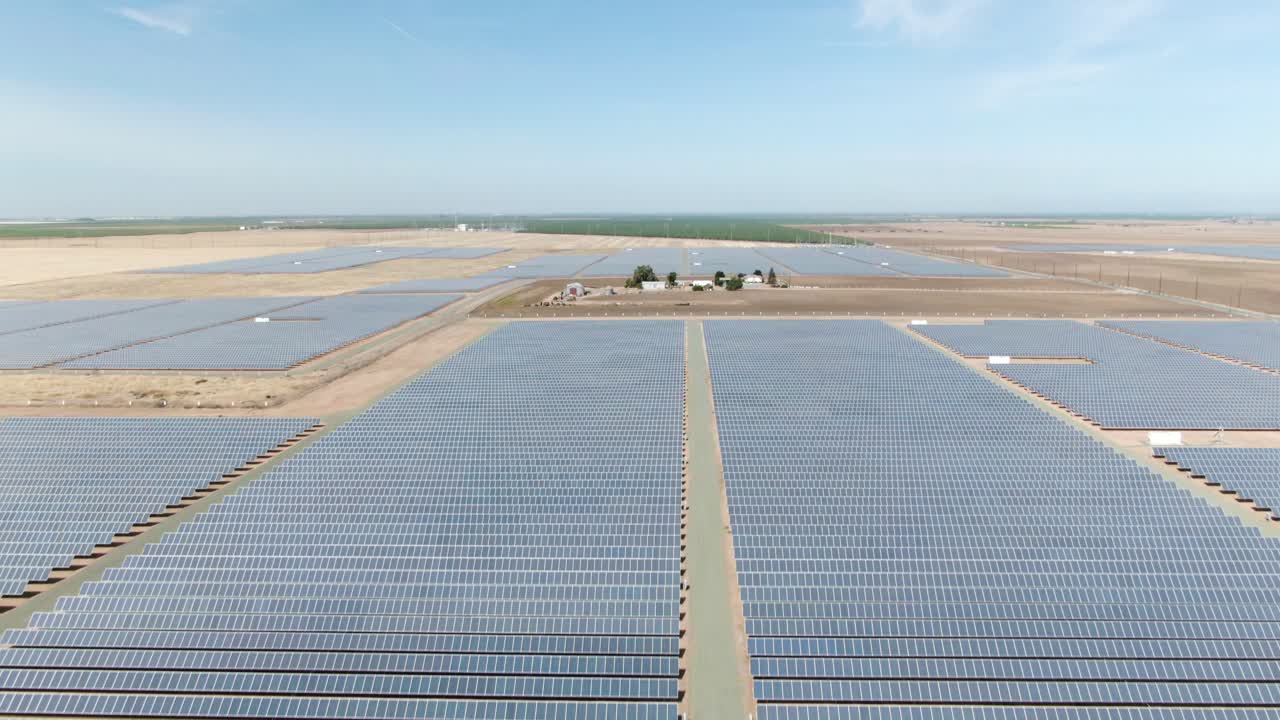 이 따뜻한 오후 동안 먼 거리에서 일부 포도원이 보이는 태양 전지판으로 덮인 들판의 수직 상승 기울기