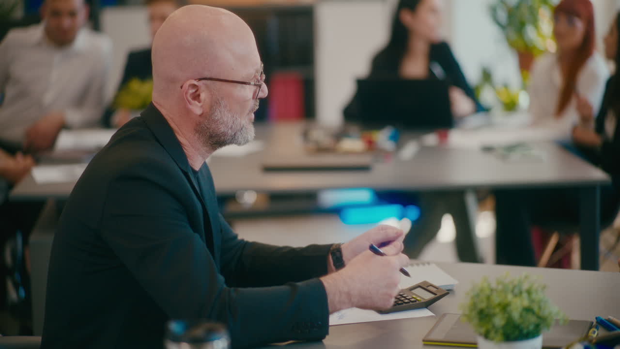 un uomo d'affari maturo che discute con un collega in ufficio.
