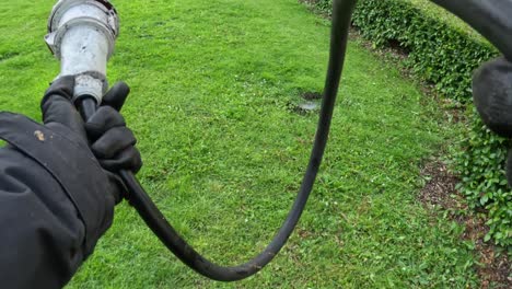 electrician holding large industrial plug on green grass outdoors