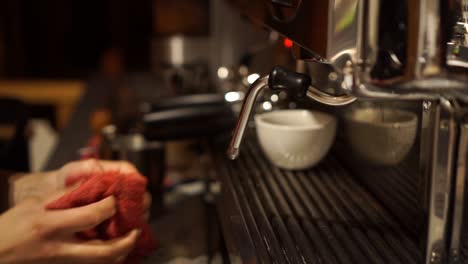 slowmo - female barista cleaning and frothing milk coffee machine - close up