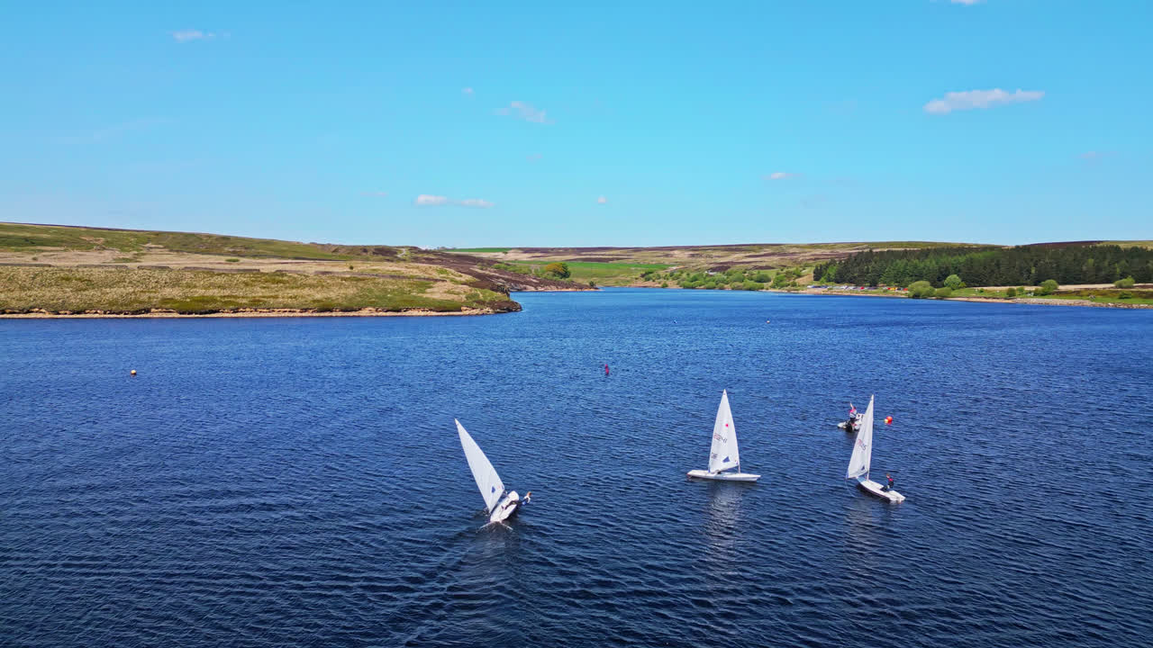 el embalse de winscar en yorkshire se transforma en un lugar animado para los entusiastas de la vela, donde pequeños barcos de una sola persona participan en un emocionante evento de carreras