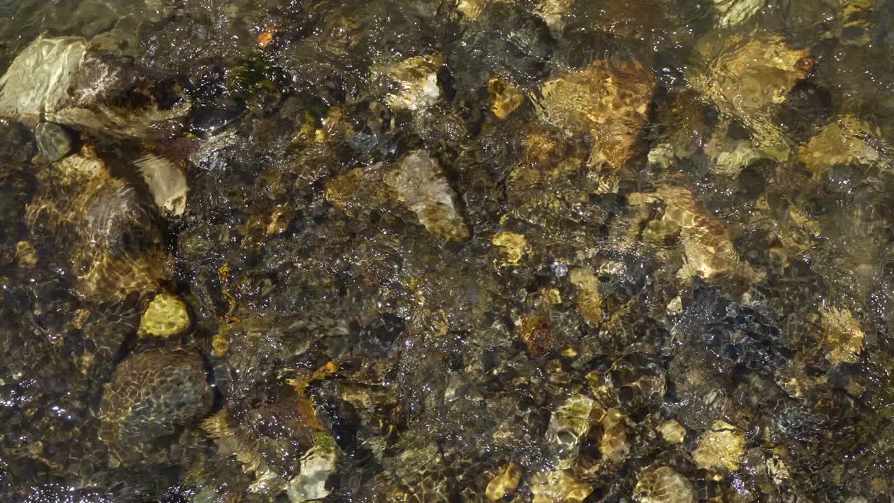 Water flowing over a river with rough rocks.