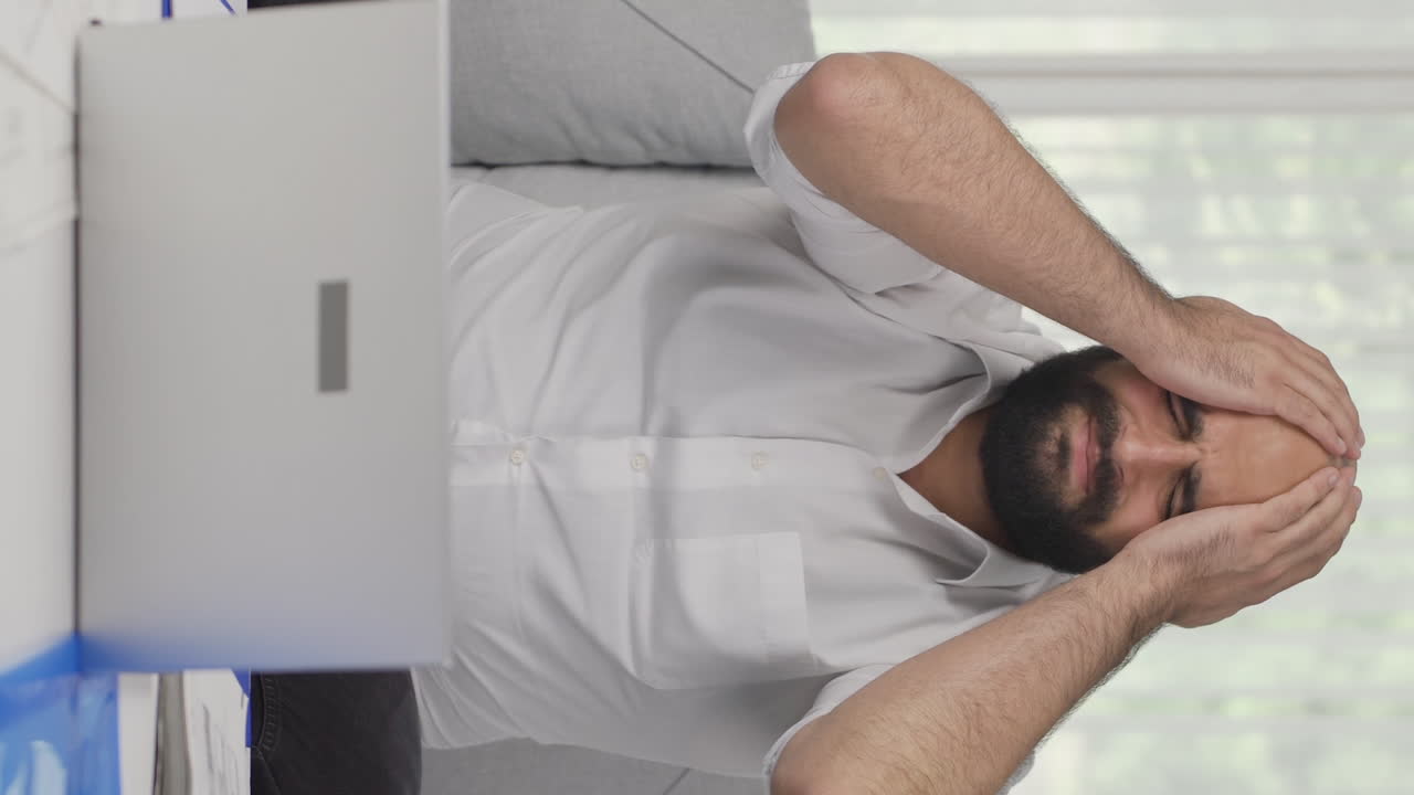 Video verticale di un uomo in smart working che vede il suo fallimento sul laptop