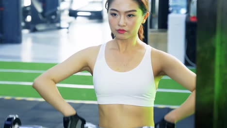 스포츠 의류 를 입은 아시아인 여성 의 초상화 운동 운동 체조 체조 체육관 에서 바벨 을 들어 올리는 운동