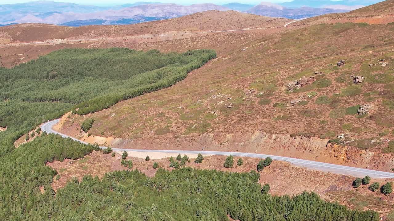 Strada tortuosa a Granada, in Spagna, con vista su paesaggio montuoso e alberi