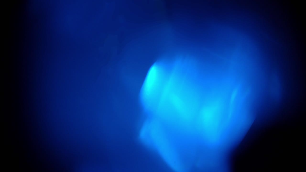 Fughe di luce blu astratte e bagliori dell'obiettivo su sfondo scuro