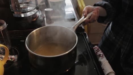 uncovering the hot pot of cooked creamy soup ready to be served - close-up shot