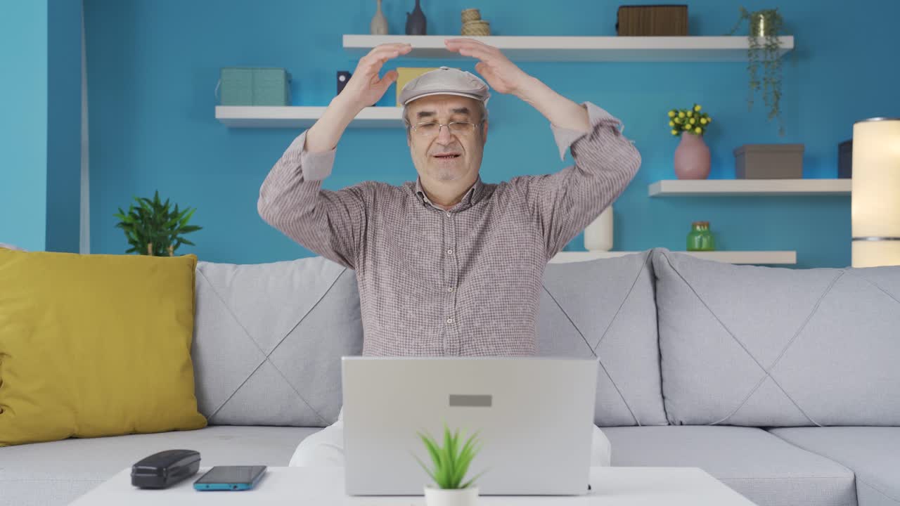 노인이 노트북에서 일을 마치고 휴식을 취하고 있습니다.