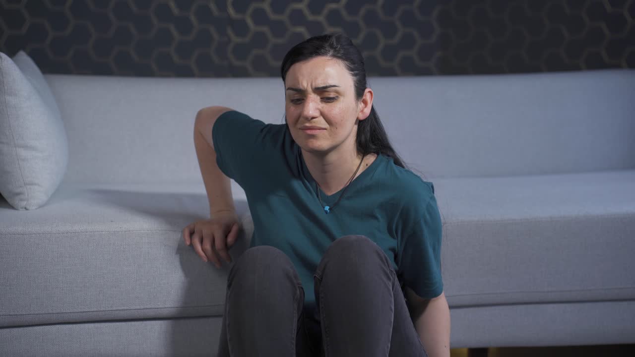 una mujer deprimida. se sienta junto a la pared.