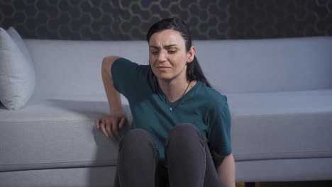 una mujer deprimida. se sienta junto a la pared.