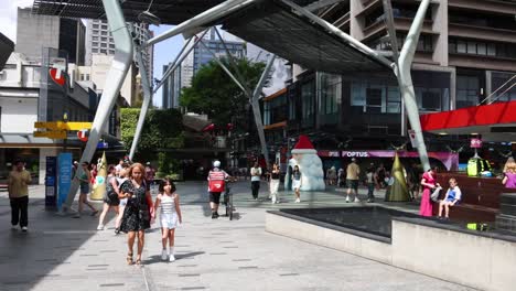 peatones caminando por una plaza ocupada