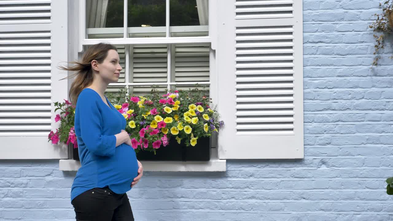 Pregnant caucasian woman walking down beautiful london street