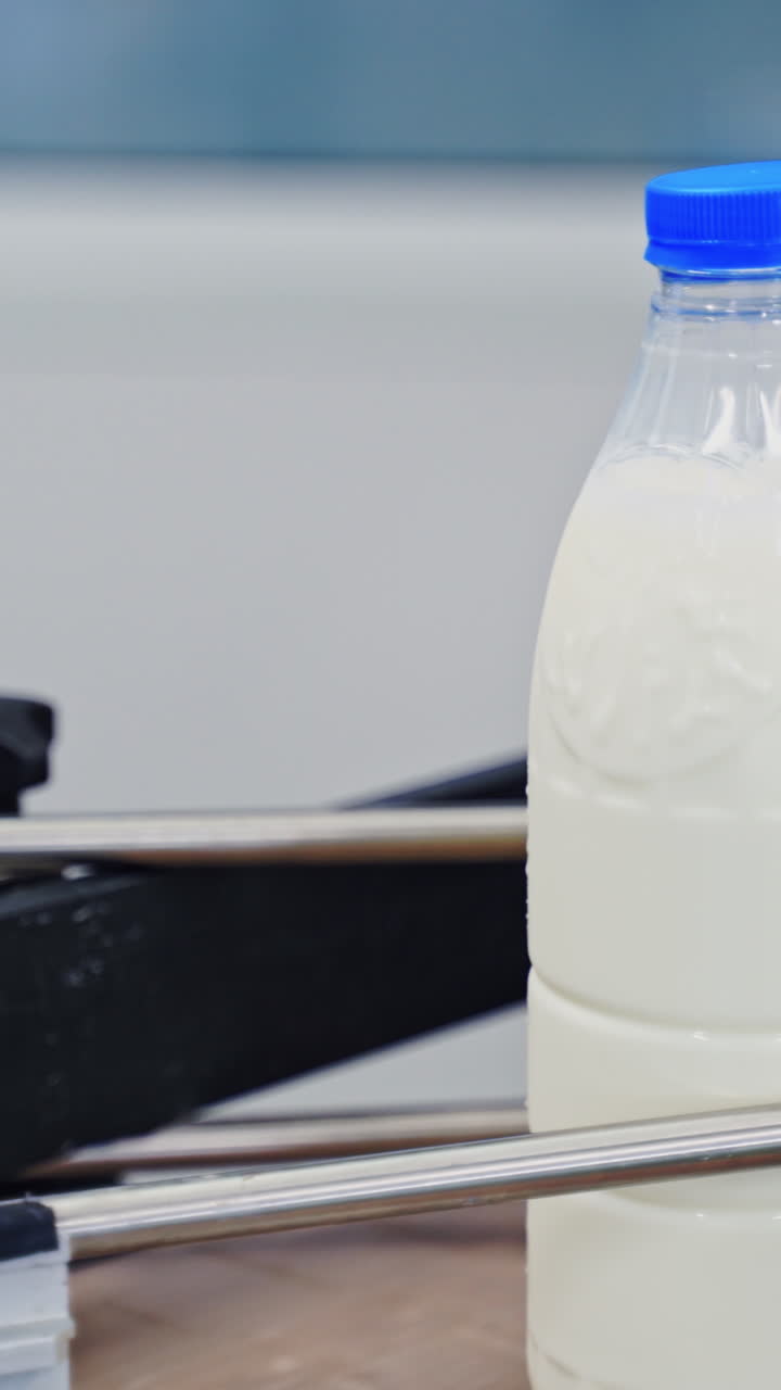Production line at dairy factory. Automated line for the production of milk in plastic bottles Vertical video