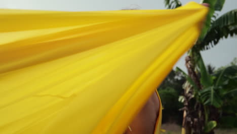 mujer con un vestido amarillo disfrutando de un día tropical