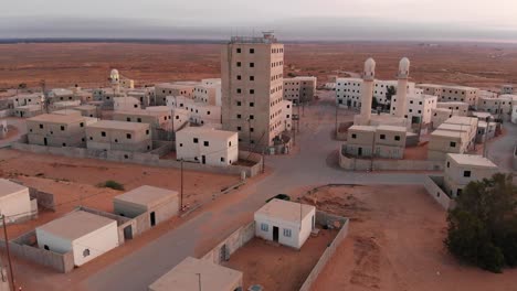 Toma-Aérea-De-Un-Gran-Edificio-En-Una-Vieja-Ciudad-Pobre-Y-Vacía-En-El-Desierto-En-Palestina-Cerca-De-Gaza-Por-La-Mañana