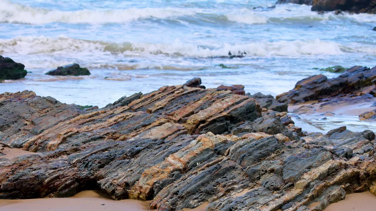 Dynamic waves crash against rugged rocks at Charlesworth Bay Beach, Coffs Harbour, under natural daylight, capturing coastal beauty