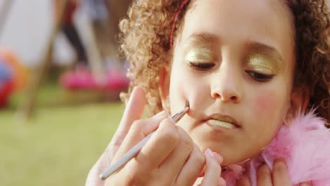 woman applying make-up on girl cheeks 4k