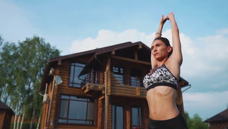 woman on the grass doing yoga on the background of a beautiful house. the concept of a healthy lifestyle