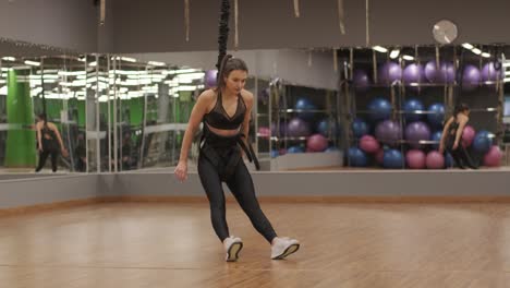 attractive woman doing aero yoga stretching exercises in hammocks at fitness studio. healthy lifestyle for female. workout gym