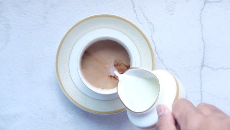 pouring milk into tea