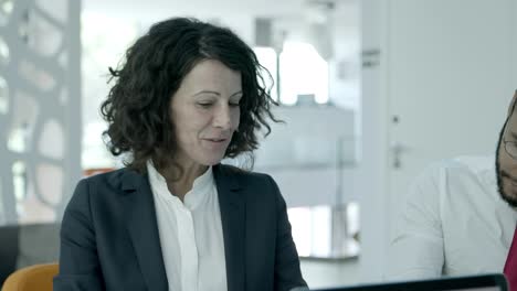 smiling businesswoman talking with colleague