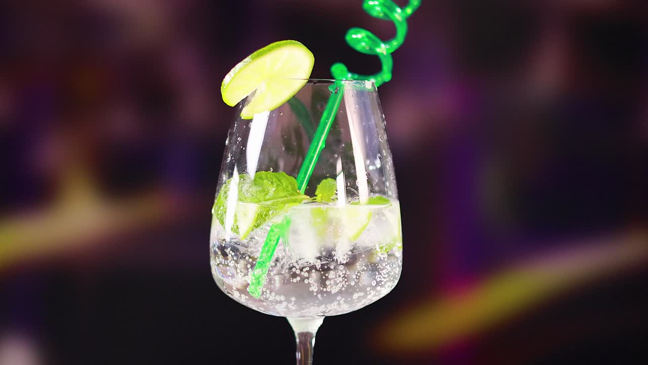 A sparkling mojito cocktail with lime and mint, set against a blurred background, highlighting vibrant colors and refreshing vibes