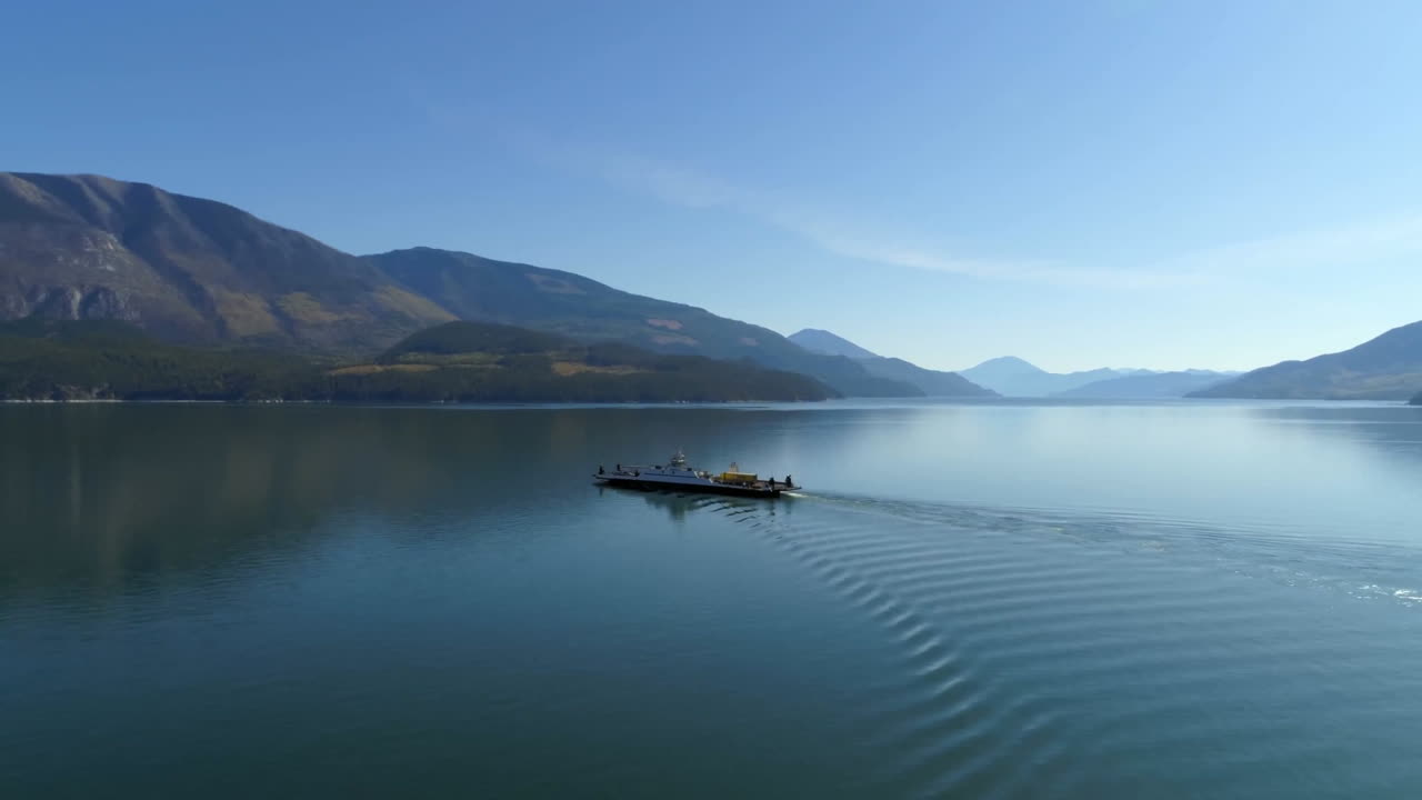 Sailing small boat on calm lake with mountains in background, creating animation