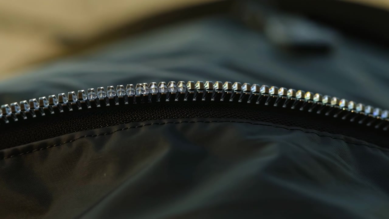 Zíper fechado, em material de vestuário, com zíper, tecido de roupa, com tecido, textura de metal, de uma perspectiva de close-up, com detalhes em azul escuro, bege claro, e humor neutro, detalhe claro